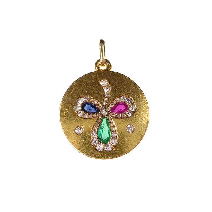 Antique gold and coloured gem set clover pendant, the circular gold panel inset with a three leaf clover formed of a pear shaped facetted emerald, sapphire and ruby,